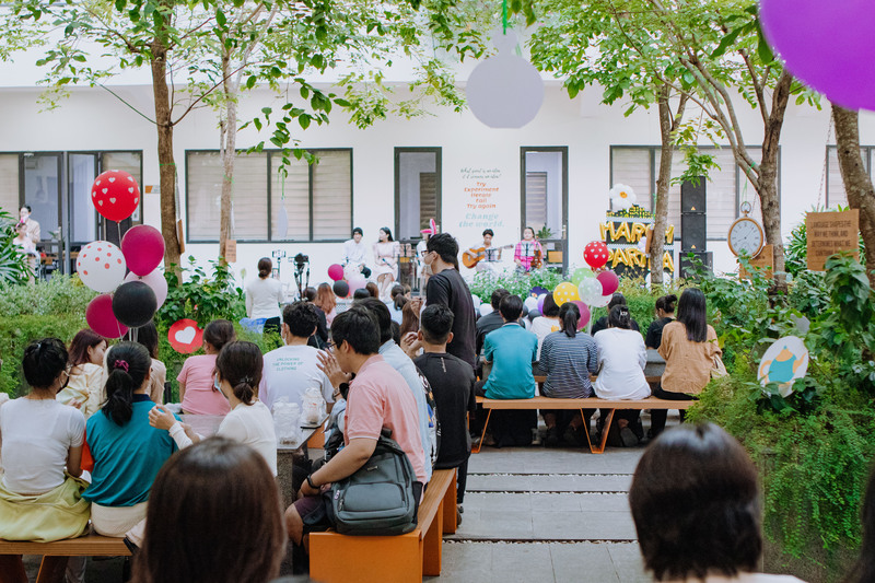 A group of people sitting on benches outside a buildingDescription automatically generated